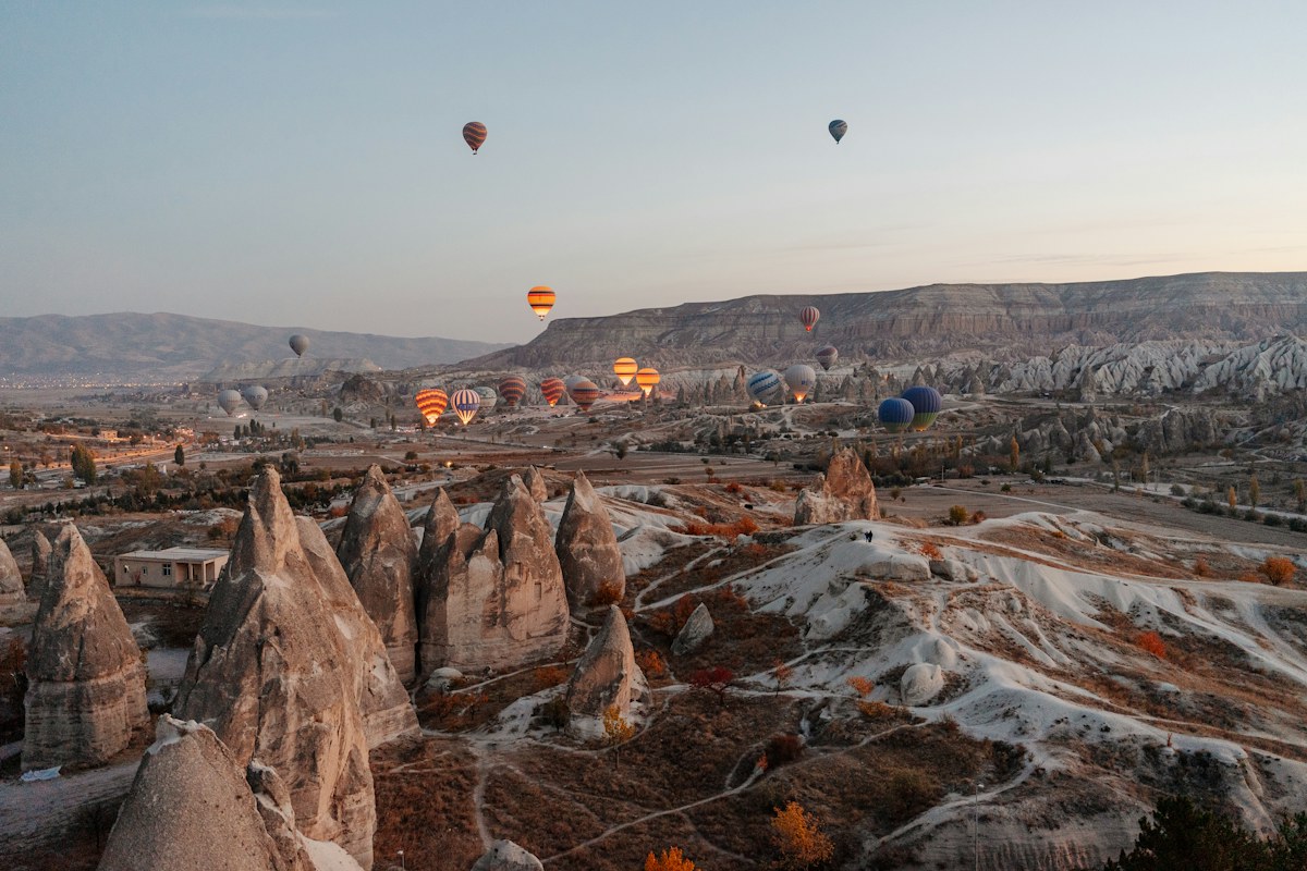 Hot air balloons floating above Cappadocia at sunrise