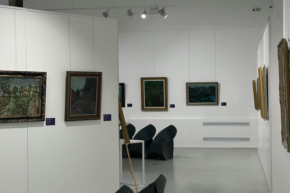 An art gallery with framed paintings and seating