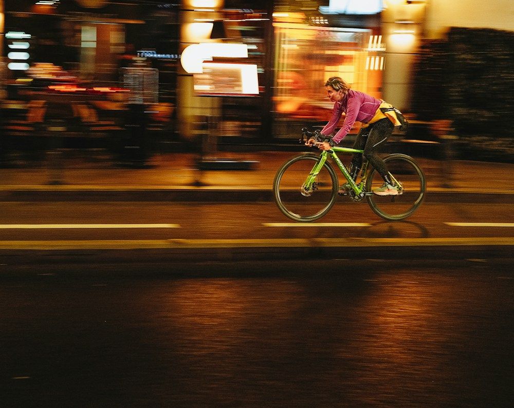 Cyclist riding through a city street after dark