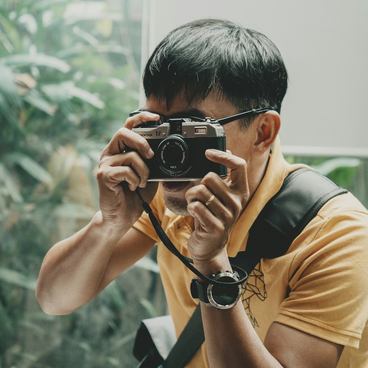 Person taking a photograph with a film camera