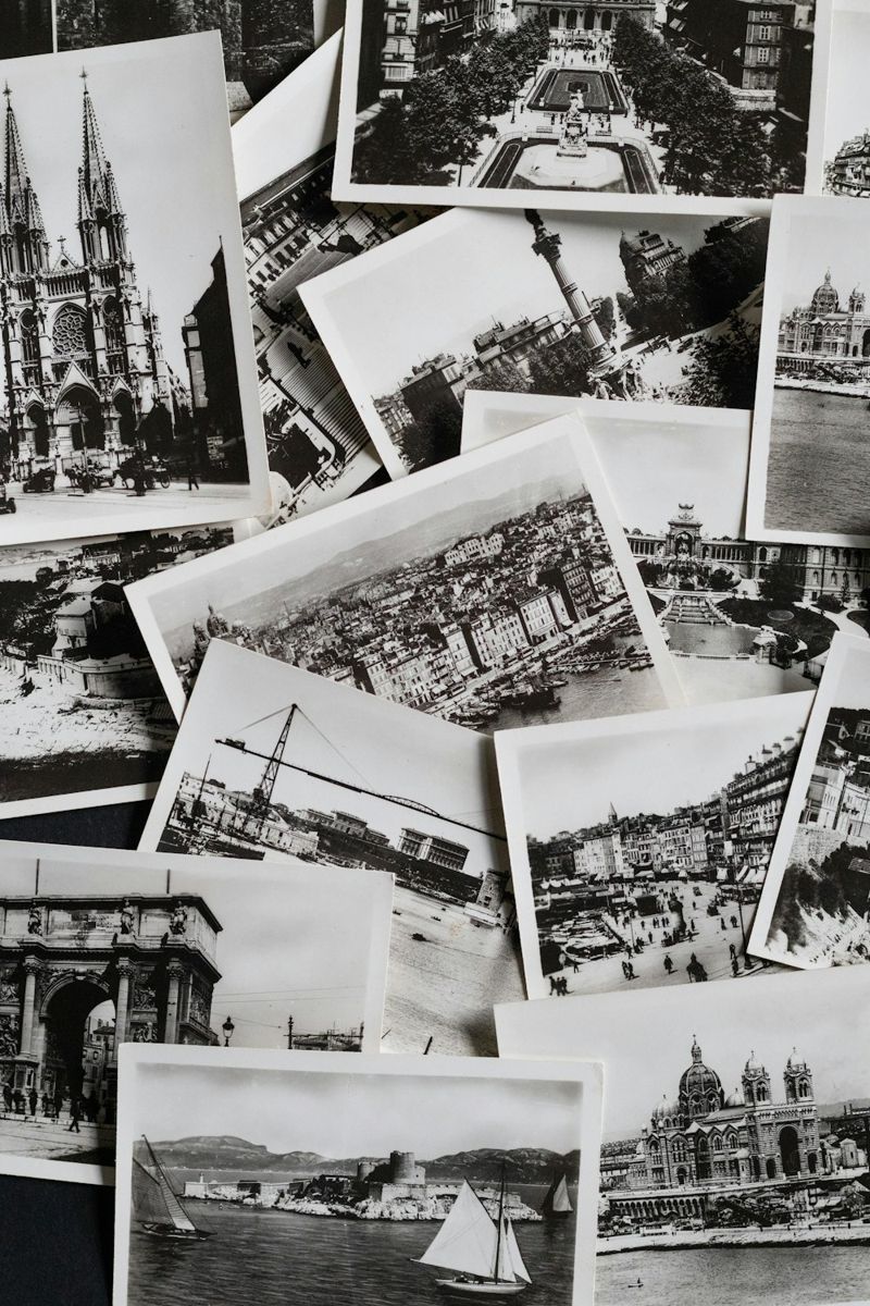 A set of monochrome postcards is displayed in an overlapping arrangement, each card capturing a distinct European landmark.