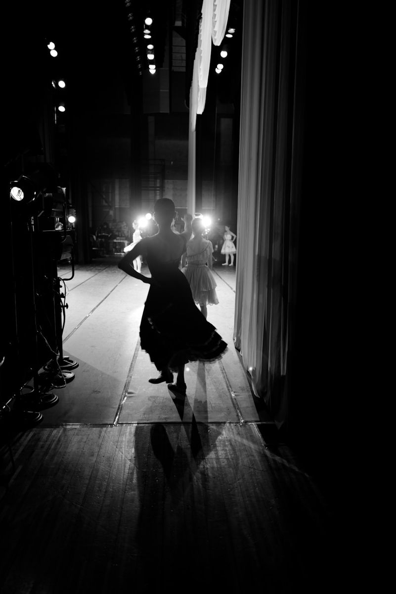 Dancers waiting backstage under stage lights