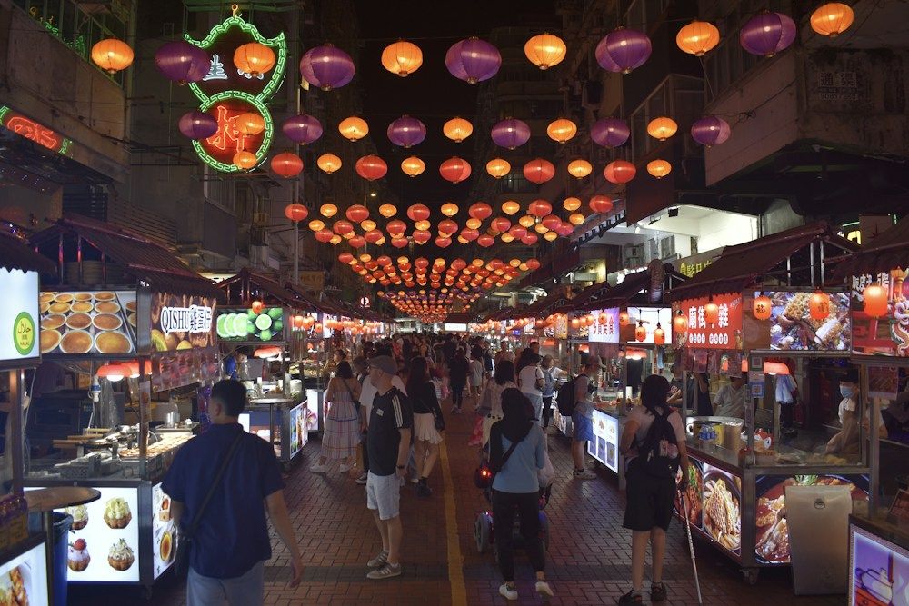Busy night market with food stalls and lanterns