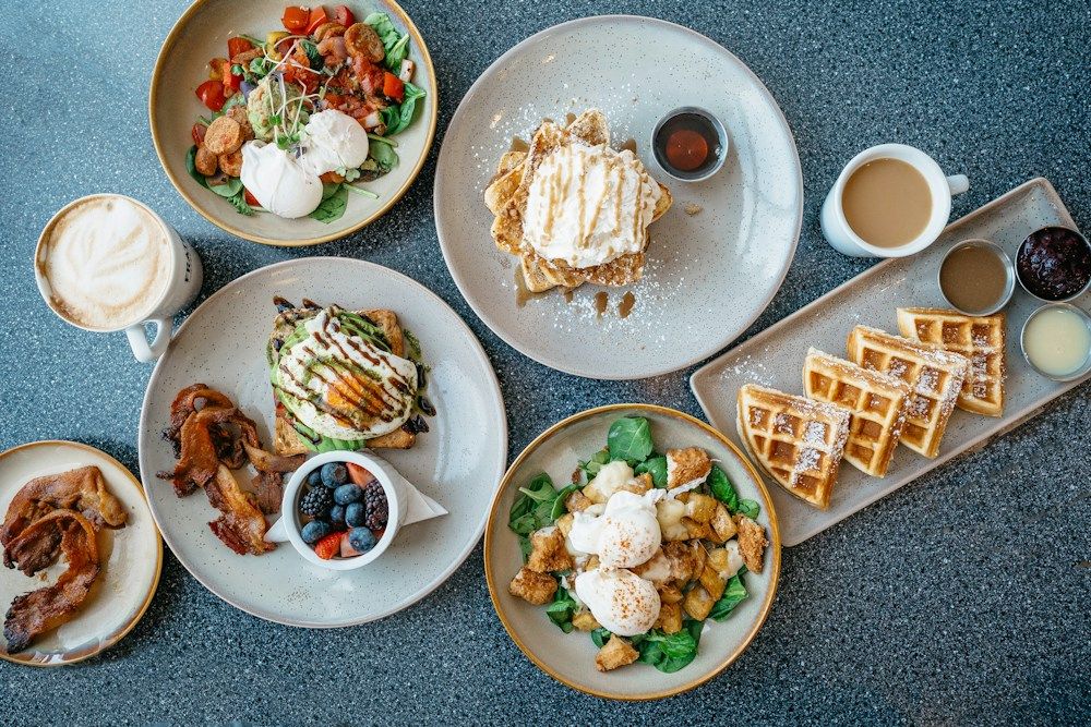 Breakfast plates with waffles, eggs and coffee