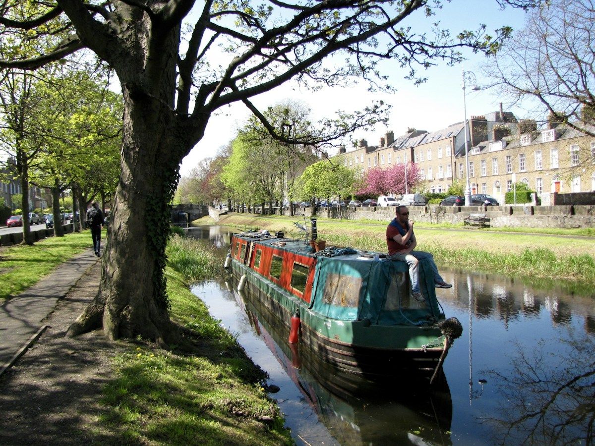 Narrowboat traveling along a tree-lined canal