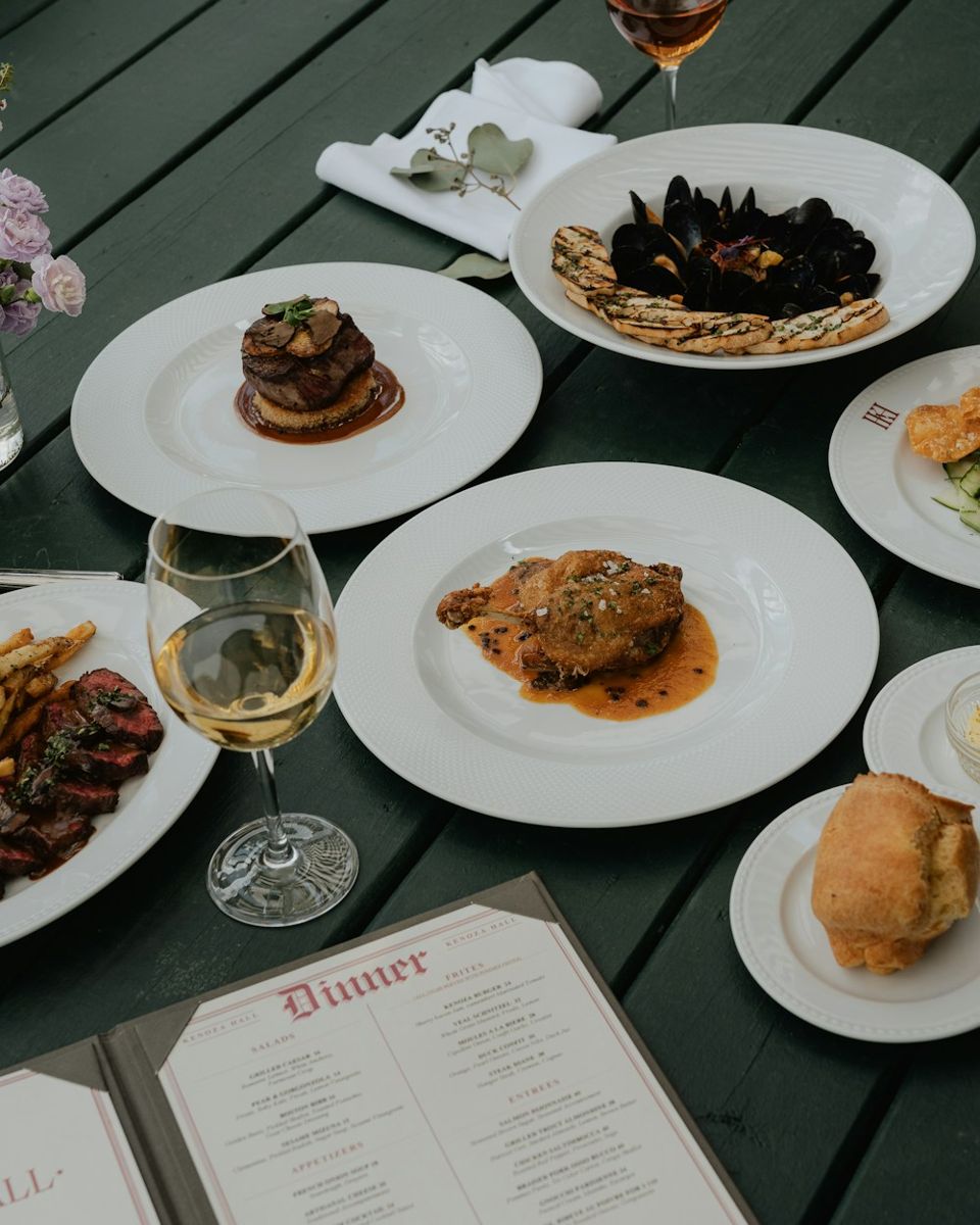Dinner menu beside restaurant plates and wine
