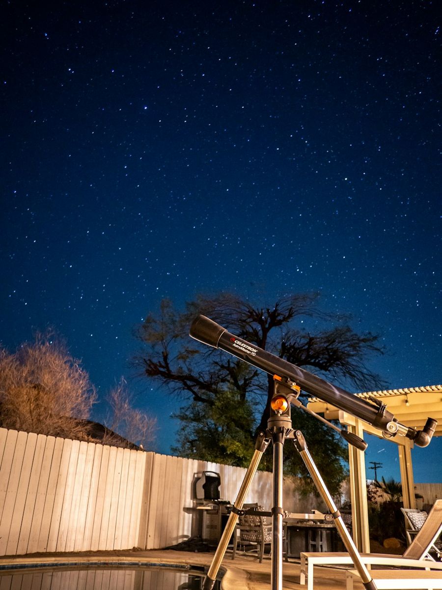 Telescope set up beneath a starry desert sky.