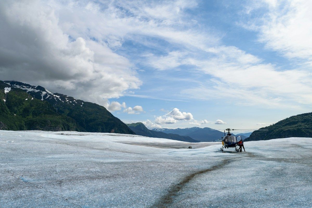 Helicopter resting on a glacier snowfield