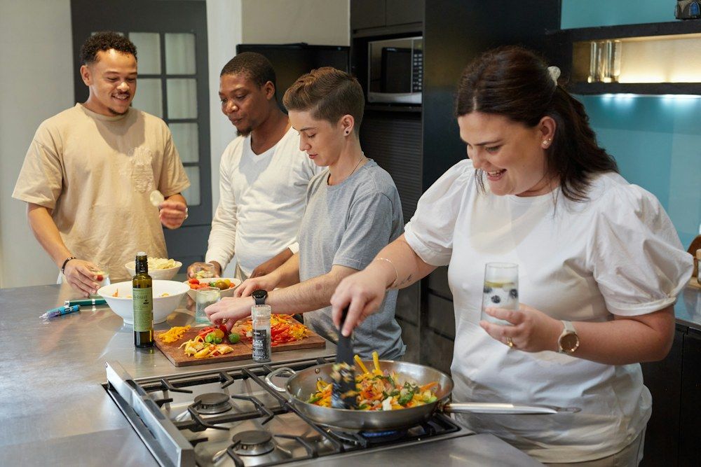 Friends preparing vegetables together in a kitchen