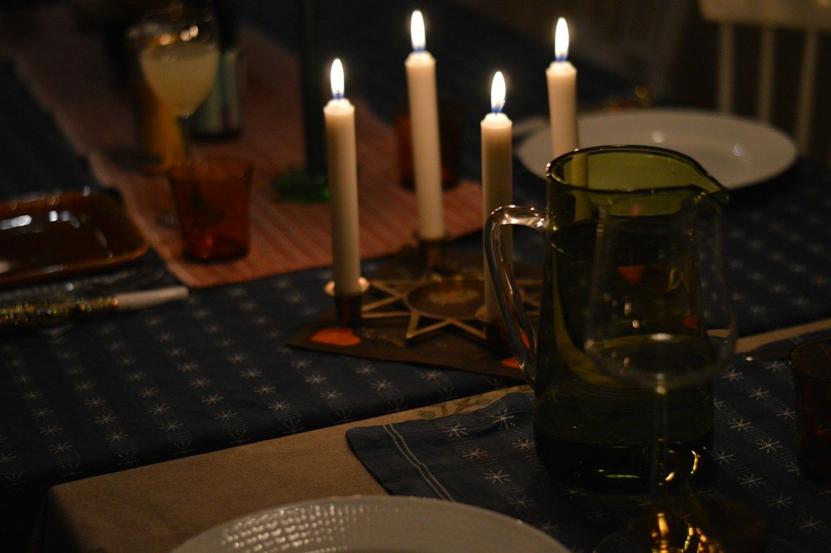 Candles glowing over a dinner table