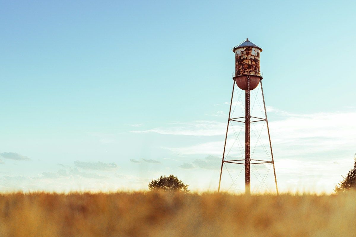 Rusted water tower in a golden field
