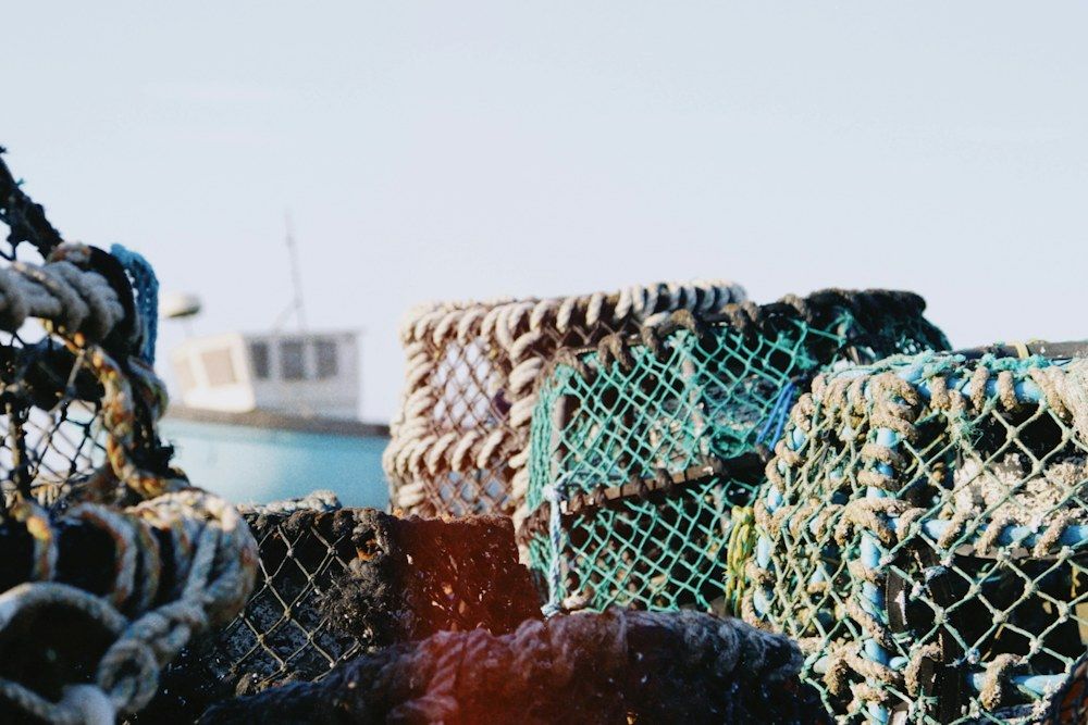 Lobster traps stacked beside a fishing boat.