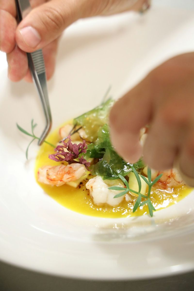 A chef finishes plating a beautiful appetizer