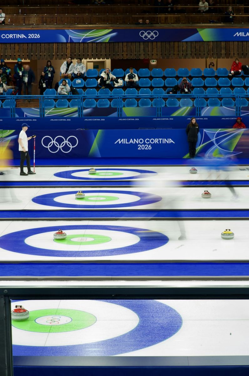 Athletes sliding curling stones across an ice rink.
