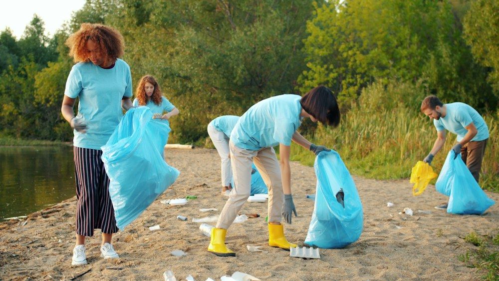 Diverse group of volunteers holding trash bags outdoors