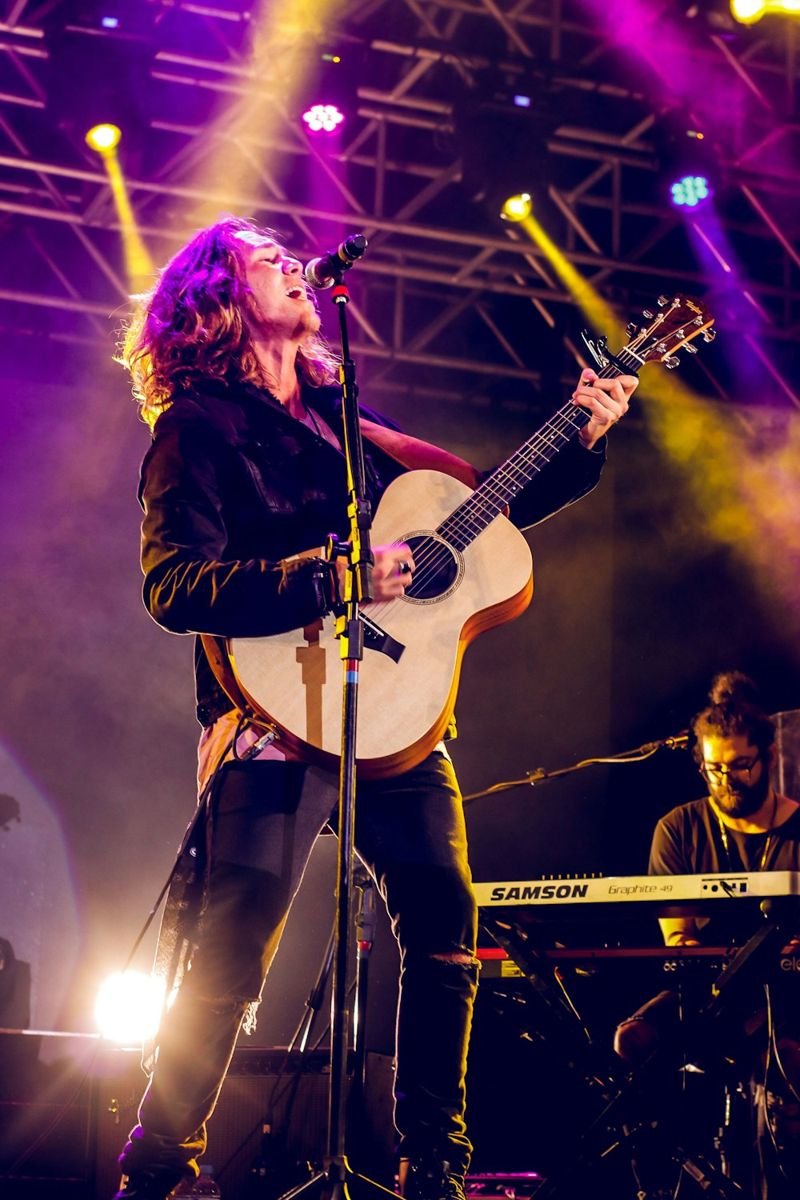 Man singing and playing guitar on stage