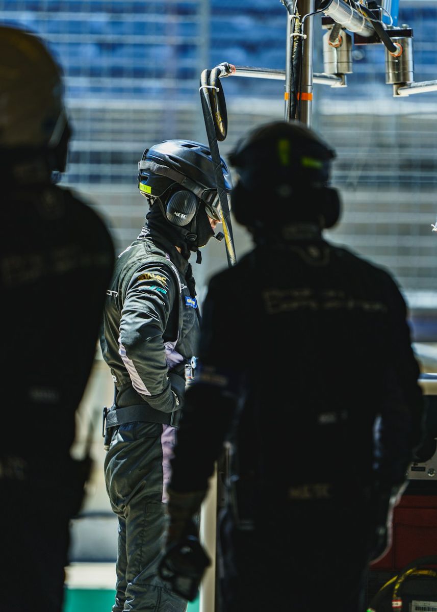 Race car pit crew members wearing helmets