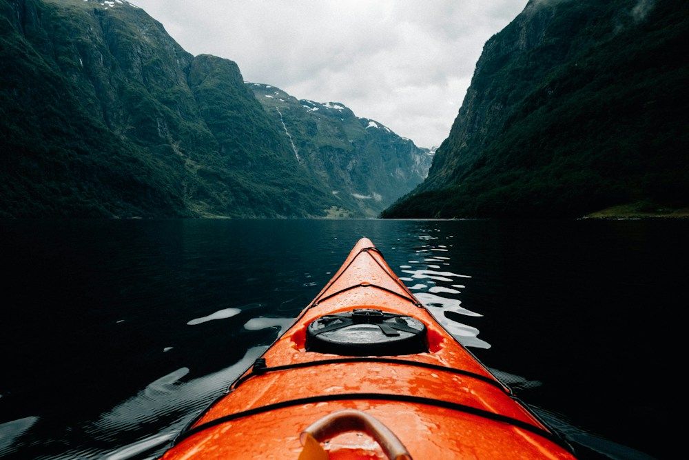 Orange kayak on a quiet fjord
