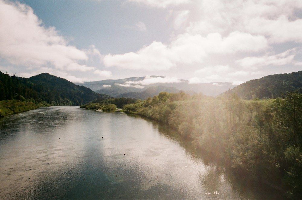 Forested river valley beneath clouds