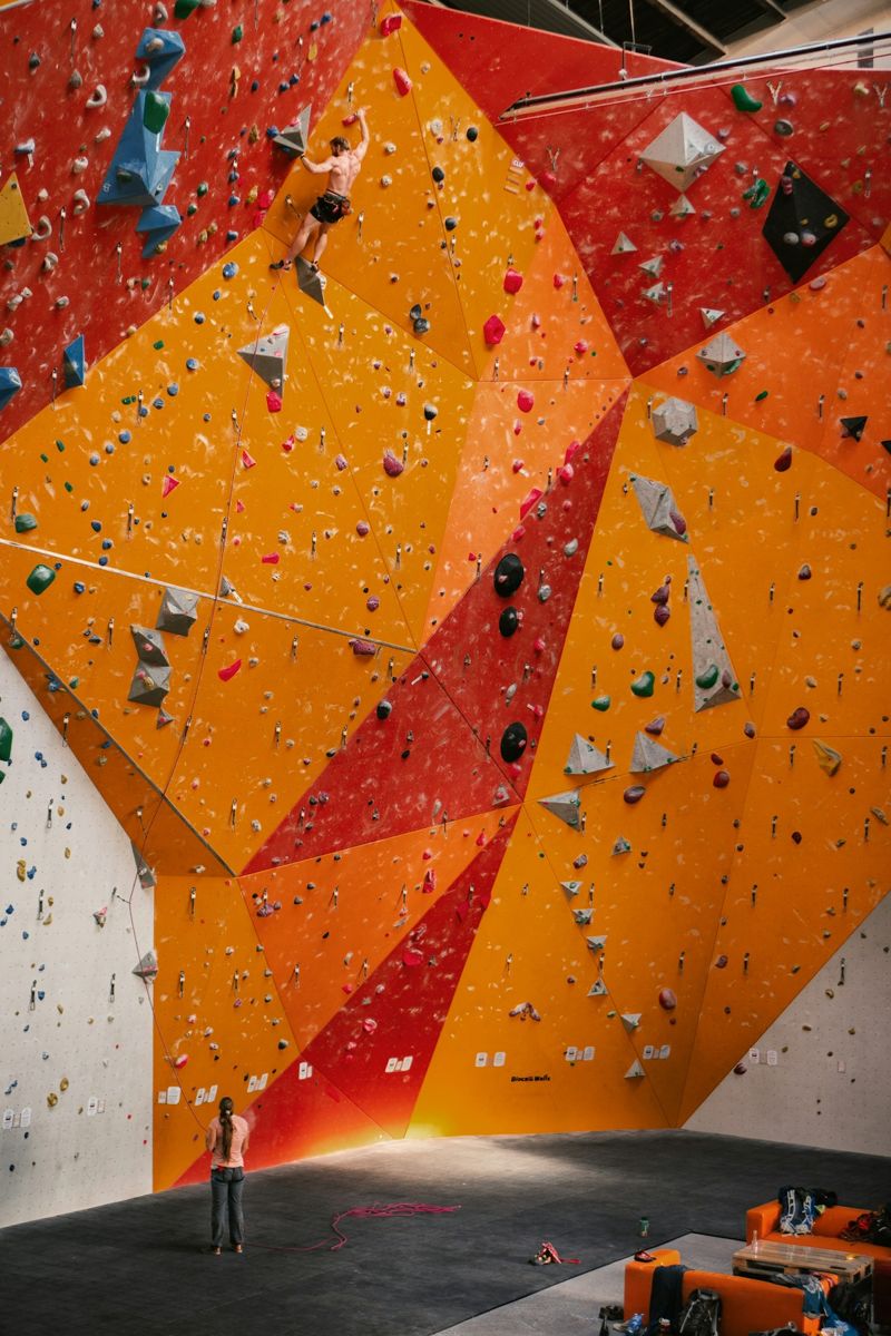 Roped climber on an orange indoor wall