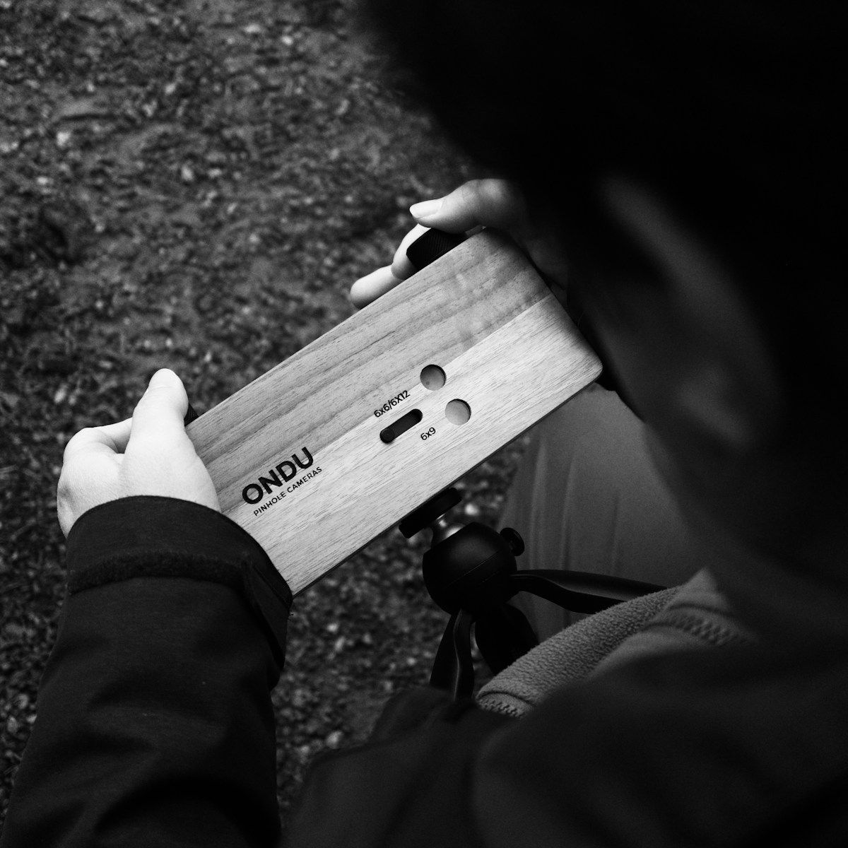 Person holding a wooden pinhole camera