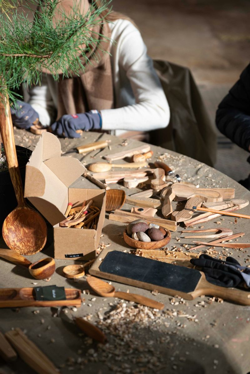 People carving wooden spoons in a workshop