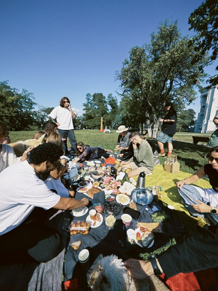 Friends sharing fruit and pastries at a park picnic