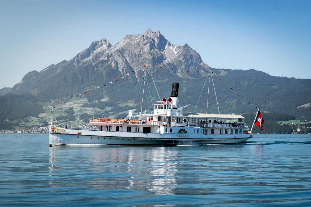Historic paddle steamer Gallia on Lake Lucerne below a mountain