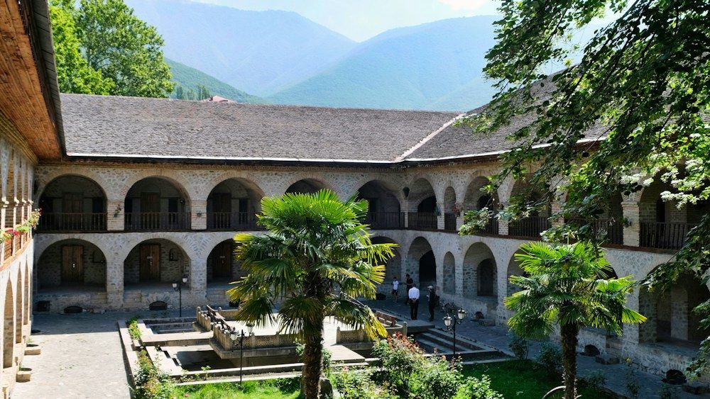The courtyard of the Rila Monastery in Bulgaria features two tiers of stone arches encircling a central fountain.