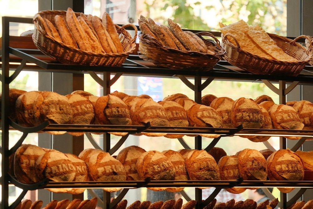 A collection of wicker baskets and metal shelves showcases an assortment of freshly baked breads.
