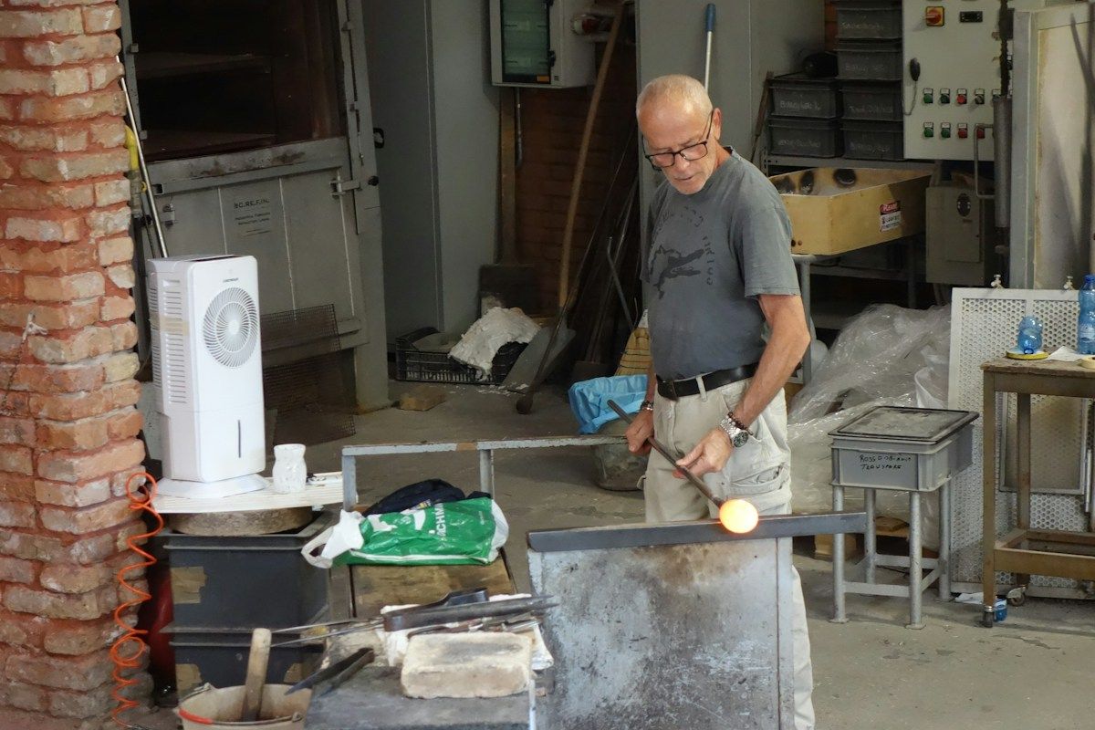 Artisan working with molten glass in a workshop