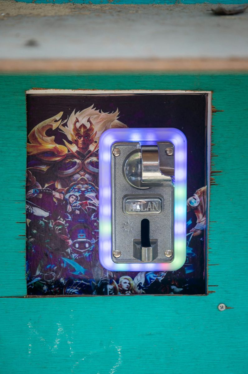 Coin slot on arcade machine with fantasy art