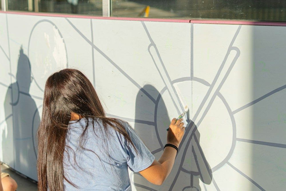 Woman painting a mural on a wall