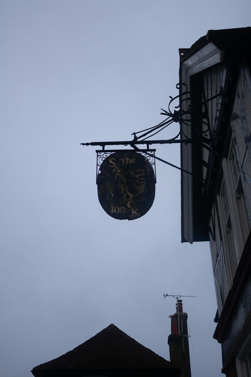 Historic inn sign against cloudy sky