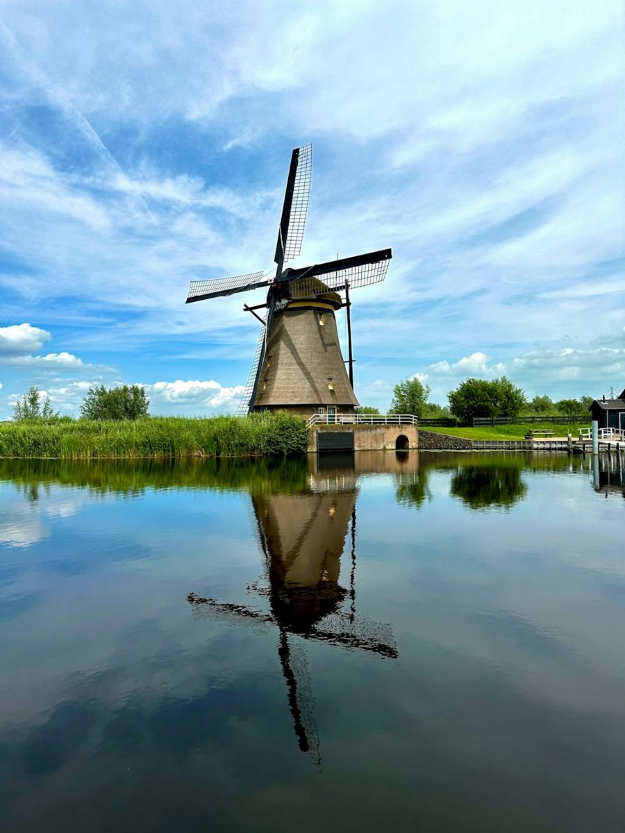 A windmill sitting on top of a lake next to a dock