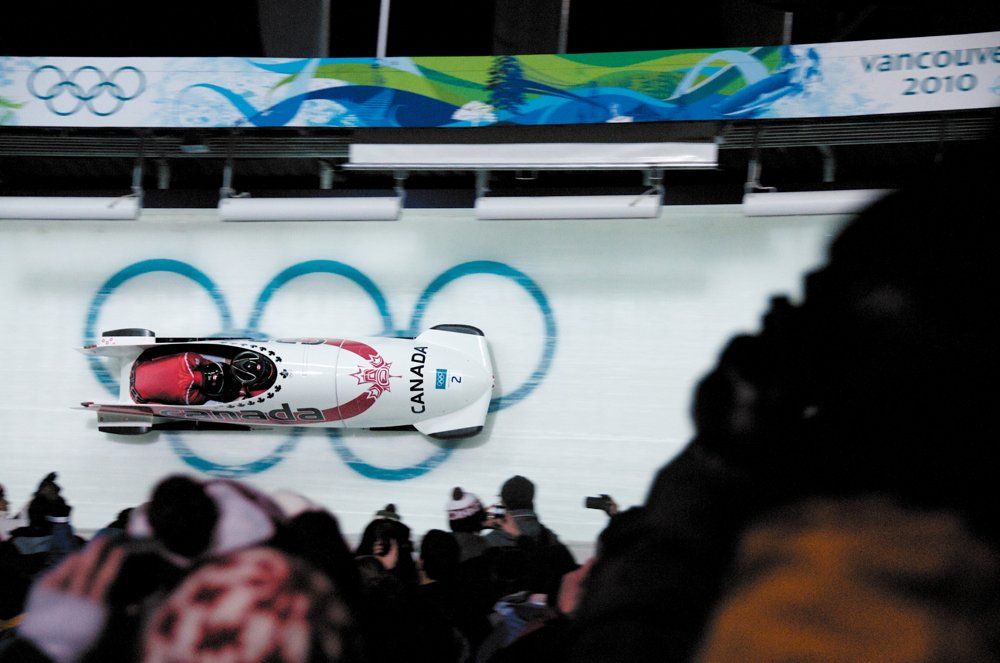 Two-person bobsled racing down the track at the 2010 Vancouver Olympics.