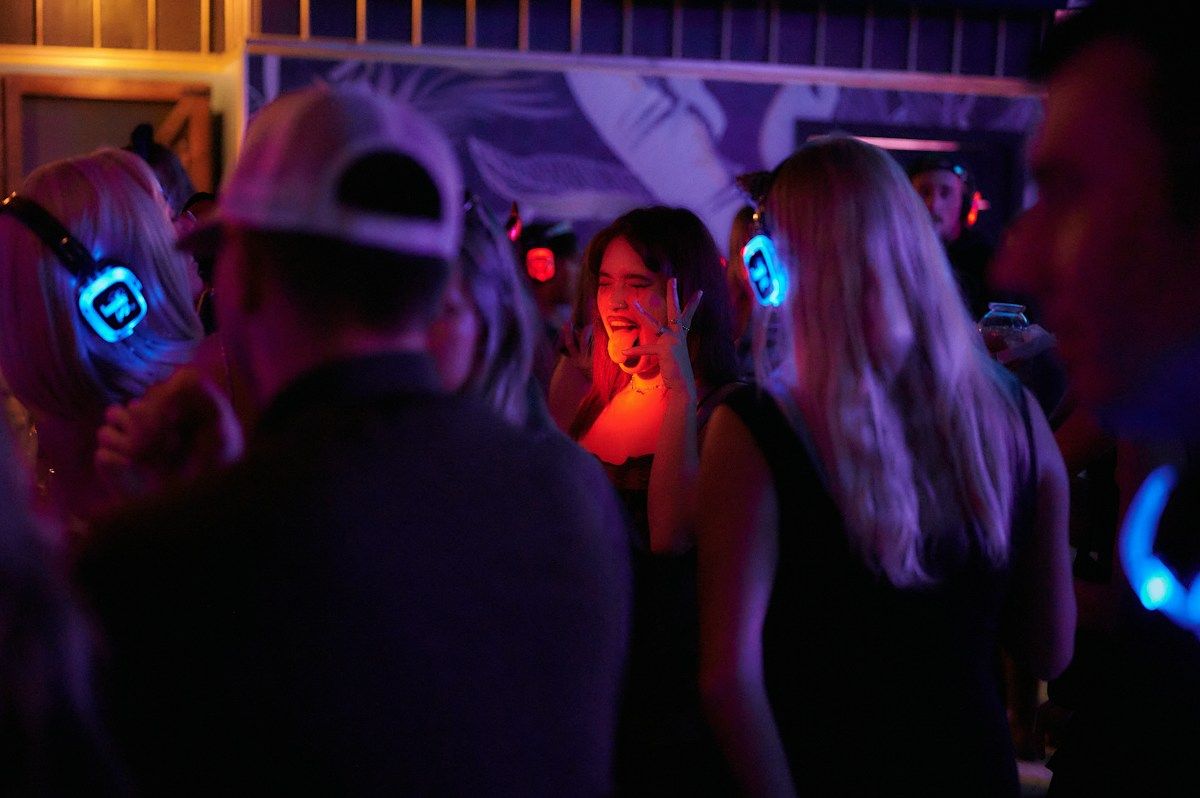 Friends wearing headphones at a silent disco