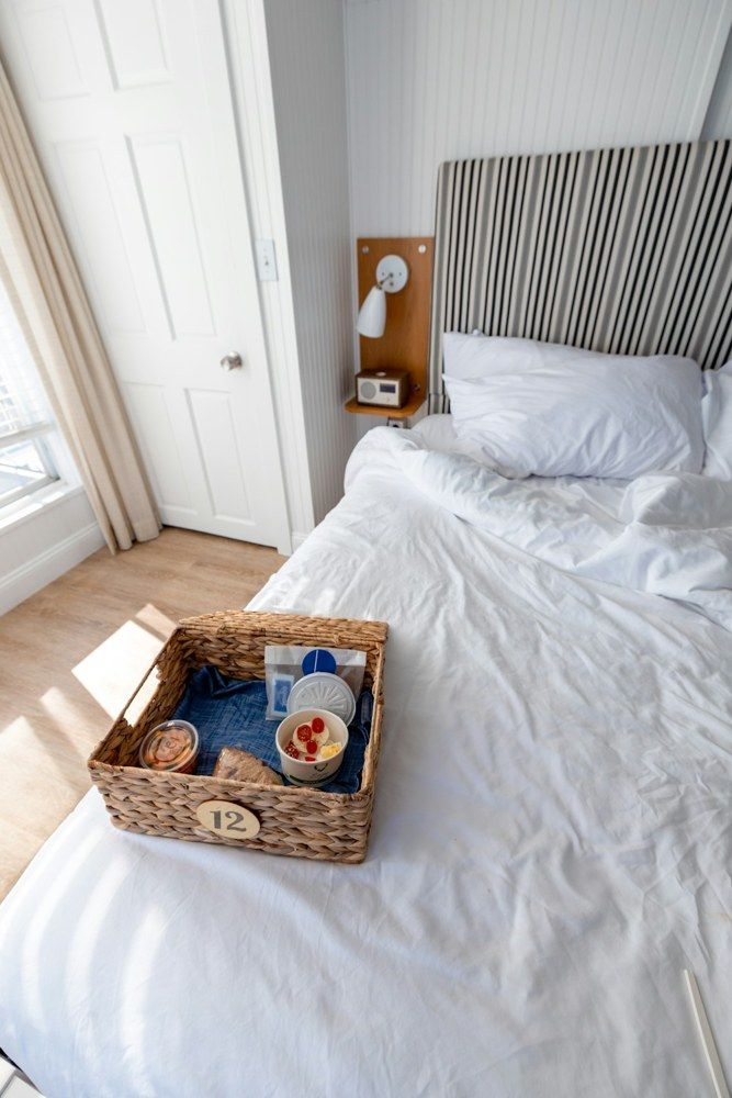Breakfast basket on a neatly made hotel bed