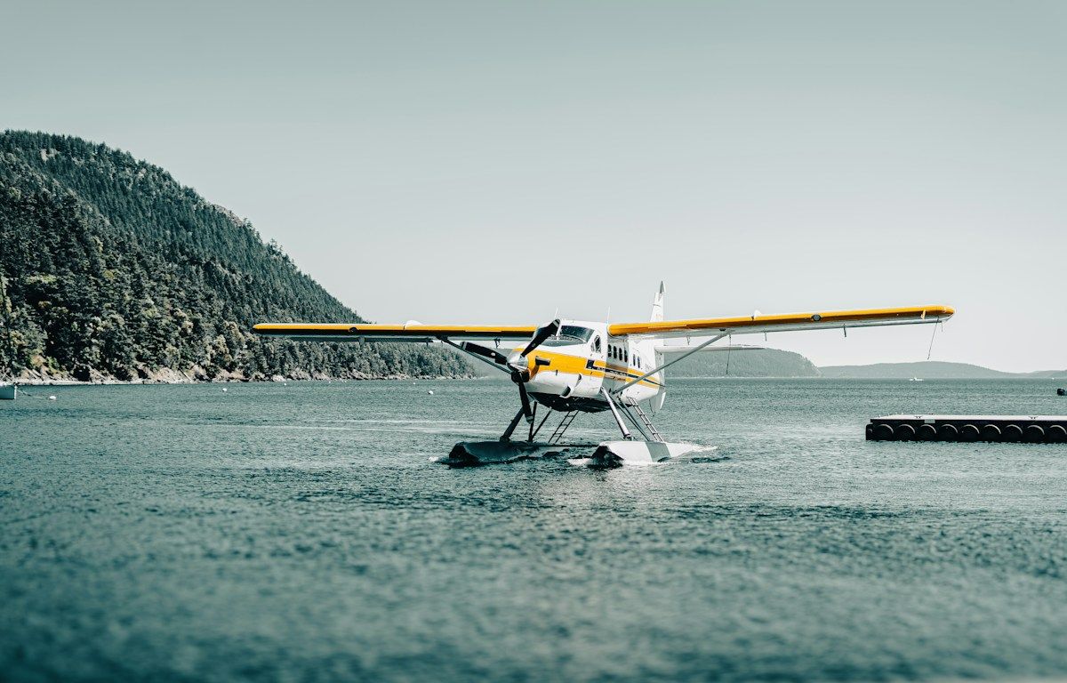 Yellow seaplane floating on a forest lake