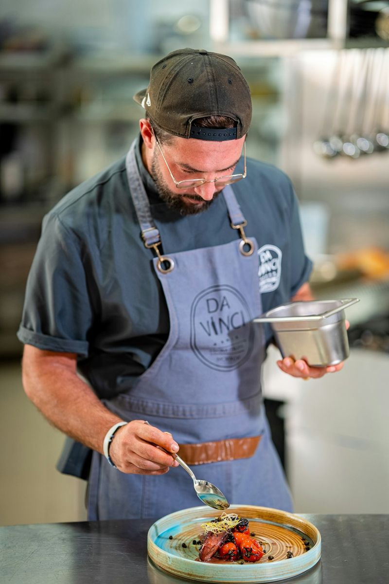 Chef carefully garnishing a gourmet dish with precision