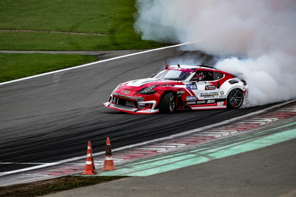 A car with smoke coming out of it driving on a track