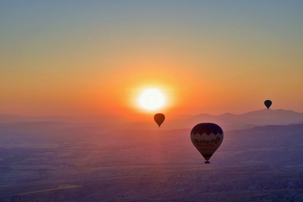 Hot air balloons rising at sunrise