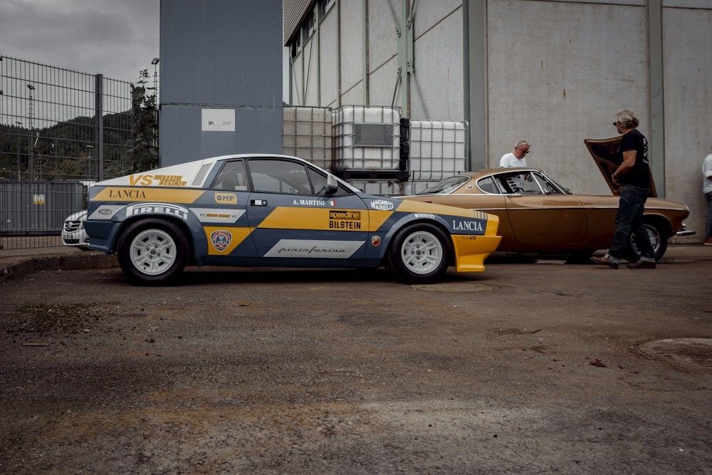 Two vintage rally cars parked side by side.